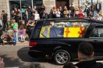 People gather in tribute as the cortege carrying the coffin of the late Queen Elizabeth II passes by in Banchory, United Kingdom.