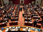 Members of the Missouri House gather in the chamber before the beginning of session on Wednesday, Feb. 3, 2021, in Jefferson City, Mo. The House chamber has no mask mandate and has not modified its seating during the coronavirus pandemic. The House canceled all work for a full week in January after a COVID-19 outbreak.