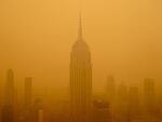 Smoky haze from wildfires in Canada obscures New York City's Empire State Building this year.  The air in the U.S. has improved over the past 50 years, but smoke pollution from growing wildfires erodes much of that progress.