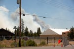 A forest fire burns just beyond road closures at Reed Road and Russell Road on the eastern edge of La Pine, Ore., on June 26, 2024. The Darlene 3 fire threatens over 1,000 structures.