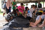 People surround a body bag in Bogo City, Cebu province, Philippines Wednesday, Oct. 1, 2025 after an offshore earthquake on late Tuesday.
