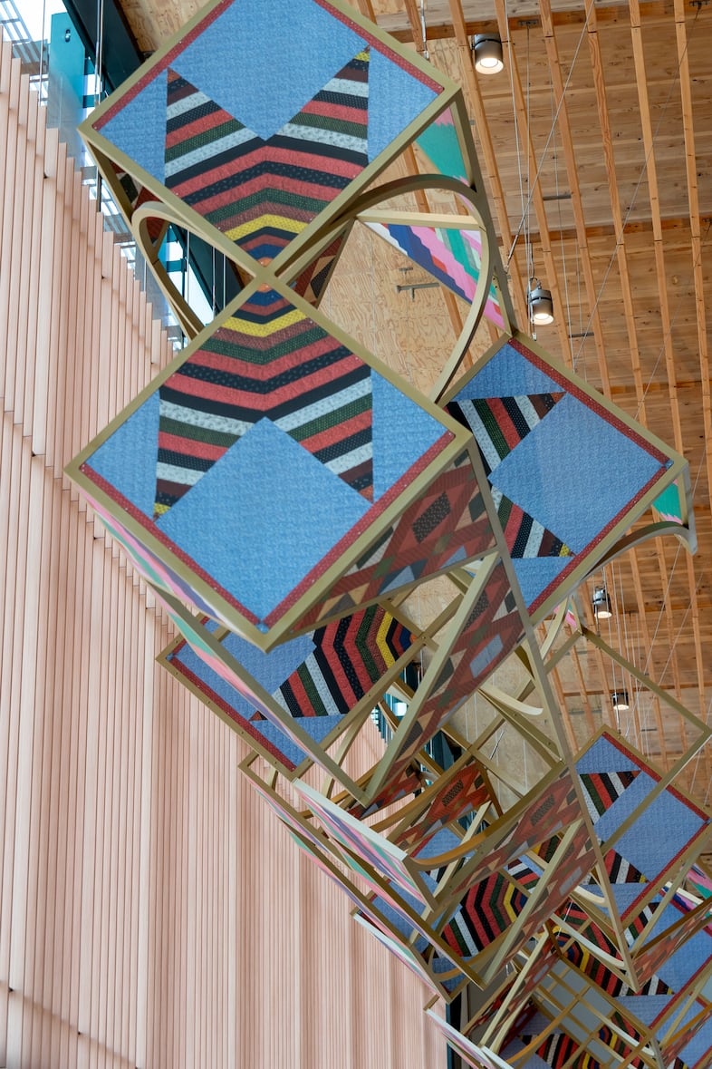 A large artwork by Sanford Biggers hangs from the ceiling in the area when travelers exit the TSA checkpoints, Aug. 2, 2024.