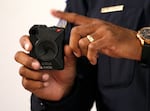 FILE - A police officer shows an Axon Body 2 body camera in Phoenix, Arizona, in 2019. The Clark County Sheriff's Office uses a similar type of body-worn camera. A spokesperson for the sheriff's office said they plan to investigate claims that deputies muted their body cameras after a deadly use-of-force incident in 2025.