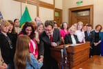 Washington Gov. Bob Ferguson hands over one of the pens he used to sign House Bill 1296, the "students bill of rights" to a child who attended the bill signing.