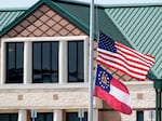 The American and state of Georgia flags fly half-staff on Thursday after a shooting at Apalachee High School in Winder, Ga.