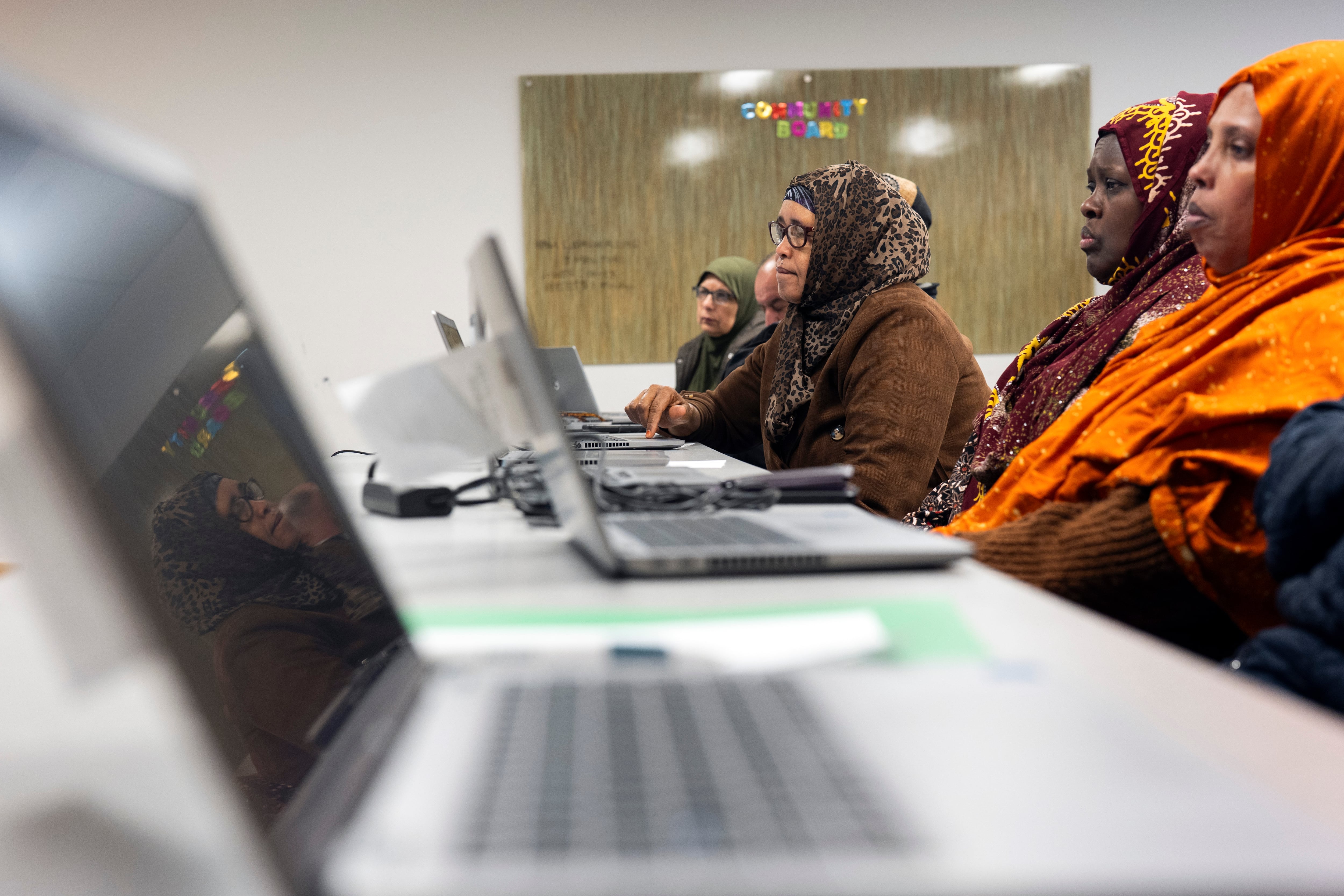Rugaya Ismail, center, is reflected in a computer screen during a keyboard basics class offered by Free Geek on Thursday, May 15, 2025, in Portland, Ore.