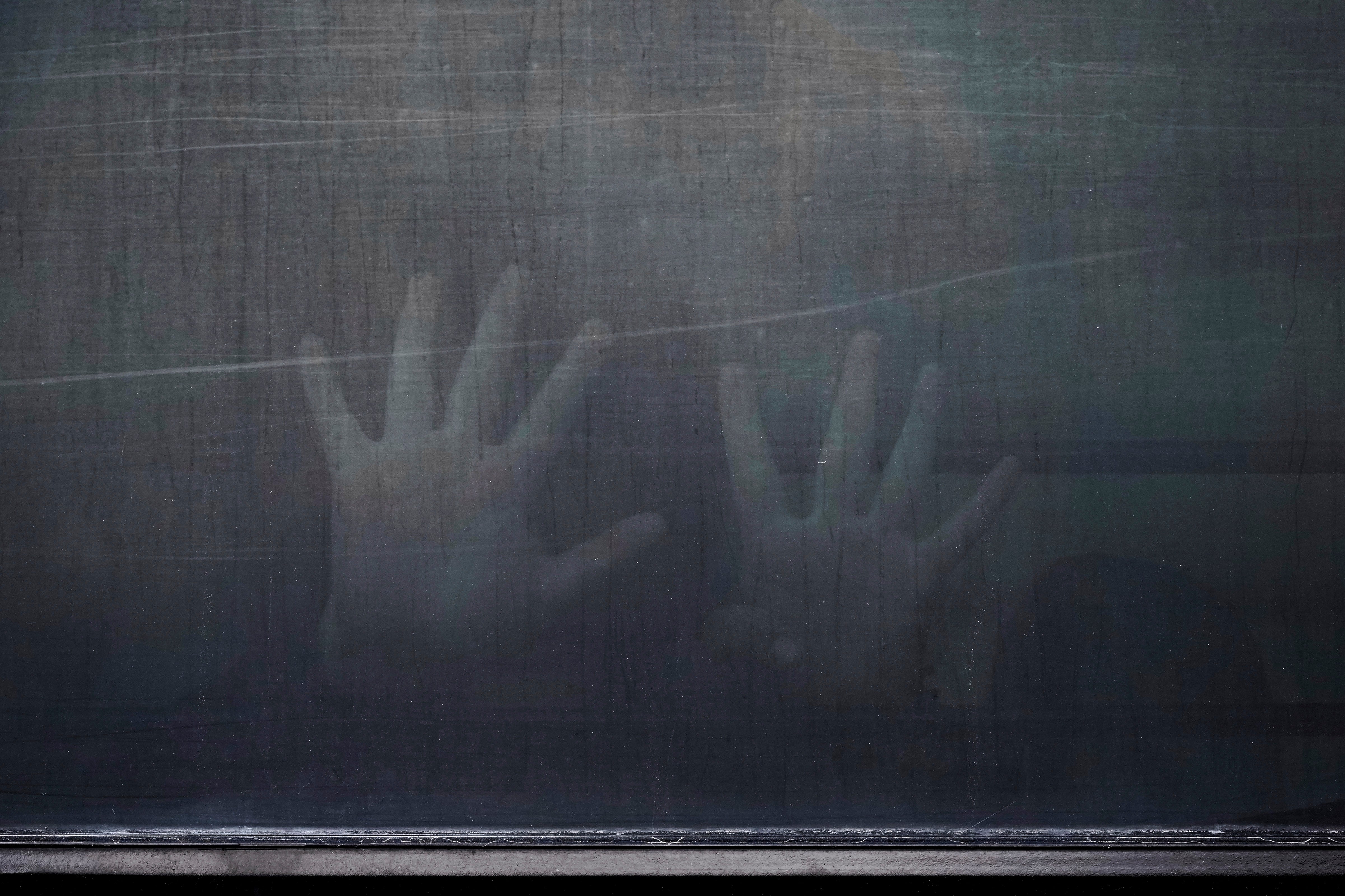 A woman from Peru signals through the barred and tinted windows of a bus after she was detained following an appearance at immigration court on June 23, 2025, in San Antonio.