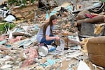 A volunteer goes through the remains of a home looking for what could be salvaged in the Sunshine Hills neighborhood in London, Ky., Monday, May 19, 2025. (AP Photo/Timothy D. Easley)