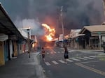 People watch as smoke and flames fill the air from raging wildfires Tuesday on Front Street in downtown Lahaina on Maui.