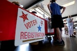 People stand near a voter registration table at a 2022 event in Fredericksburg, Texas.