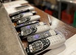 Several TV remotes sit behind the counter at Icarus Wings and Things in Salem, Ore., on Oct. 20, 2023. Icarus is a restaurant and bar dedicated to gluten-free food and women's sports. The owners said it is difficult to find a steady stream of women's sports on TV, so they often make a patchwork schedule using cable and streaming services.