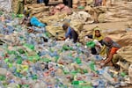 Pakistani laborers, mostly women, sort through empty bottles at a plastic recycling factory in Hyderabad, Pakistan.