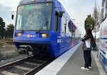 A woman waits for the MAX Green Line at the Lents Town Center MAX stop. The Green Line will be significantly reduced due to TriMet's budget shortfall.