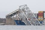 The steel frame of the Francis Scott Key Bridge sits on top of the container ship Dali after the bridge collapsed, Baltimore, Md.