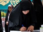 A woman fills out her ballot during the Iranian presidential election in a polling station at the shrine of Saint Saleh in northern Tehran, Iran, on Friday. 