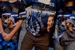 Daniel Alvarado, 13, Carlos Flores, 50, and Kimberly Alvarado, 16, wear President Bukele t-shirts in downtown San Salvador on Jan. 31. Flores says he has lived in the state of Virginia and Washington D.C. for the last 25 years, and he supports President Bukele's re-election because of the work he has done in terms of security and infrastructure in downtown San Salvador.