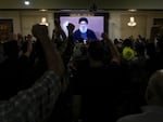 Hezbollah supporters raise their fists and cheer as they watch a speech given by Hezbollah leader Hassan Nasrallah during a ceremony to commemorate the death of a senior Hezbollah commander in the southern Beirut suburb of Dahiyeh, Lebanon, on Wednesday. 
