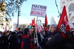 A protester against French President Emmanuel Macron holds a placard reading "Macron, you stink, get out," during a rally in Marseille, France, on Thursday, as part of a day of action and strike in the public sector.