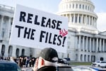A protester holds a sign related to the release of the Jeffrey Epstein case files outside the U.S. Capitol on Nov. 12, 2025.