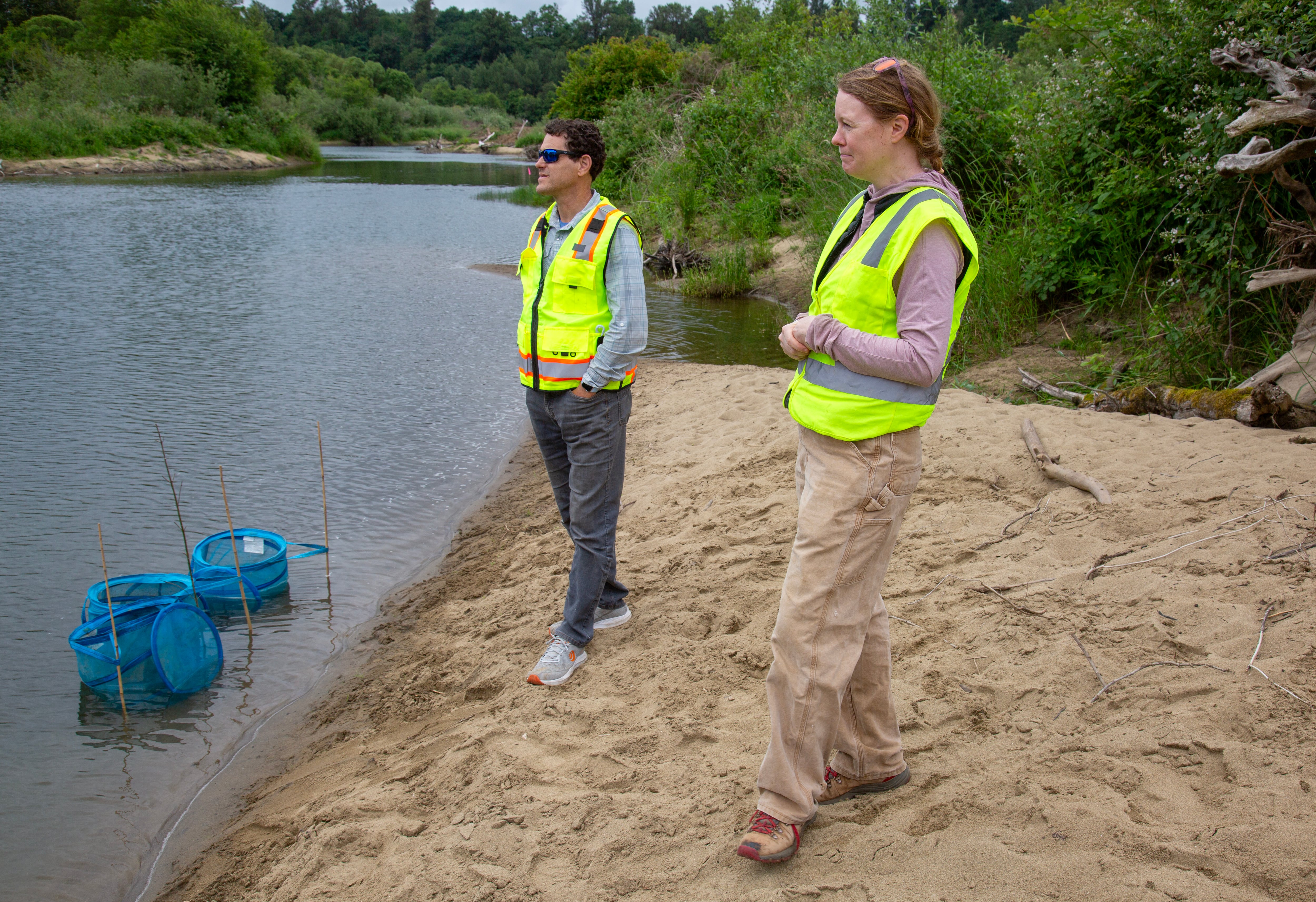Paul Kolp and Jasmine Zimmer-Stucky of the Lower Columbia Estuary Partnership stand at the edge of one of the Ridgefield Pits on June 4, 2025.