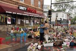 Visitors Taylor Walters and Gerardo Rodriguez Orellana embrace as they take in the memorial space at George Floyd Square, Wed., May 21, 2025, in Minneapolis, Minn.