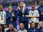 Team members for the United States — including Maher in the center of the top row — and New Zealand pose at the medal presentation ceremony for the Rugby Sevens in Saint-Denis, France on Tuesday.