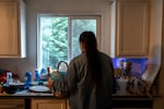 Nancy washes dishes at her home in Portland, Ore., on Dec. 2, 2025. OPB is only using Nancy’s first name at her request to protect her family’s safety.