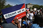 Protesters hold signs saying “COUNT ME IN” at a 2019 rally against the Trump administration’s push for a census citizenship question outside the U.S. Supreme Court in Washington, D.C.