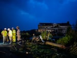 Utility workers survey storm damage along Cothran Road on Wednesday in Columbia, Tenn.