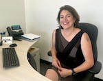 Salem-Keizer Superintendent Andrea Castañeda sits at her desk and turns to smile at the camera.