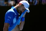 Novak Djokovic of Serbia wipes the sweat from his face during his semifinal match against Alexander Zverev of Germany at the Australian Open tennis championship in Melbourne, Australia, on Friday.