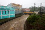 A river swollen with rain caused by Hurricane Fiona speeds through Cayey, Puerto Rico.