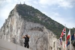 A Spanish police officer uses a pair of binoculars on the first day of passport-free travel under a new EU-U.K. treaty, at the border crossing between Gibraltar and Spain in La Línea de la Concepción, Spain, Wednesday, July 15, 2026.