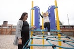A pregnant mother and her toddler son spend time at a playground.