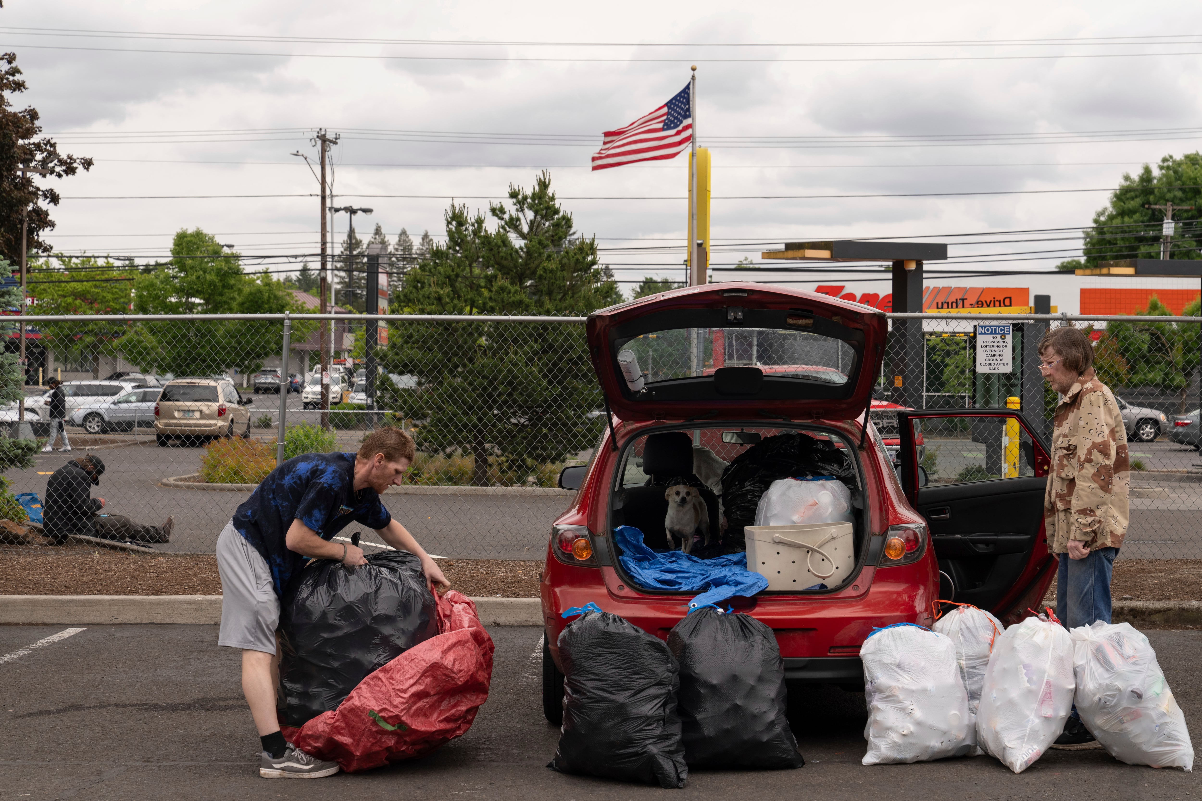 Chris Grass, left, and his father Todd Grass, right, prepare to take over 1,000 used beverage containers inside the Glisan BottleDrop Redemption Center.