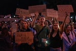 People chant while holding banners during a protest against a law targeting anti-corruption institutions in central Kyiv, Ukraine on Tuesday.
