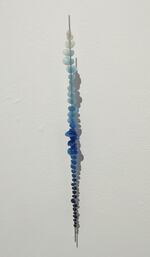 Ellen George's vertical wall sculpture "Pacific Blue" uses polymer orbs that illustrates the varying intensities of blue.