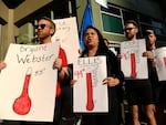 Protesters hold up signs outside of the Denver Public Schools administration building to demand equity for students attending classes in excessively hot classrooms.