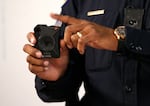 FILE: An officer in the Phoenix Police Department demonstrates an Axon body camera in 2019, in Phoenix, when that city launched its body-worn camera program. 
