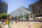 Children play in the splash zone at Director Park in downtown Portland.