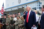 Holding a microphone, President Trump gives remarks to law enforcement officers at the U.S. Park Police's Anacostia Operations Facility in Washington, D.C., on August 21, 2025. On the left side of the frame are two rows of people, some of whom are wearing camouflage-patterned uniforms.