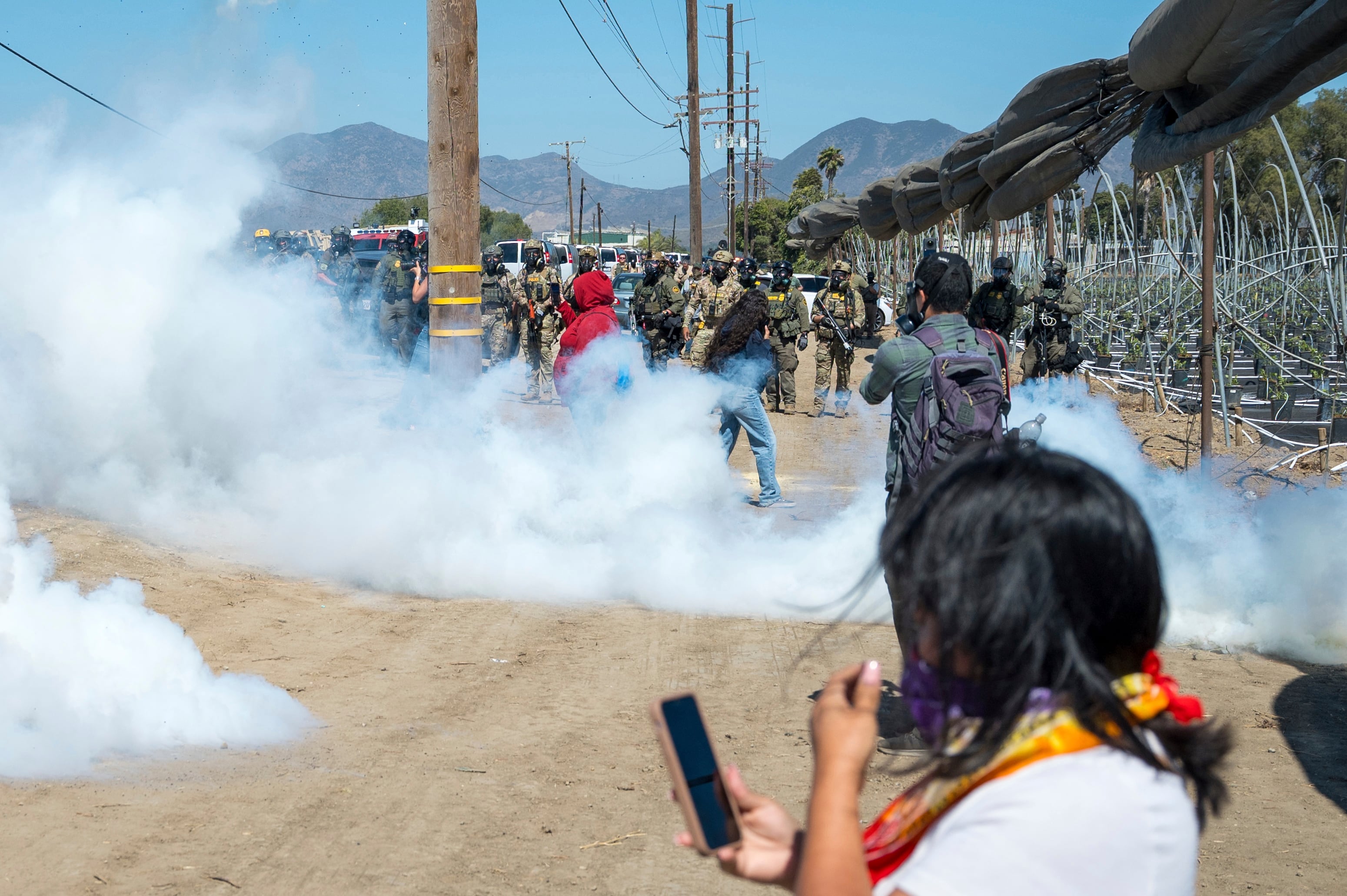 Federal immigration agents toss tear gas at protesters during a raid in the agriculture area of Camarillo, Calif., Thursday, July 10, 2025.
