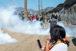 Federal immigration agents toss tear gas at protesters during a raid in the agriculture area of Camarillo, Calif., Thursday, July 10, 2025.