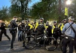 Several Portland Police Bureau officers surrounded a man during an arrest at Portland State University May 5, 2025. Protesters opposed a campus speaking event for conservative activist Riley Gaines.