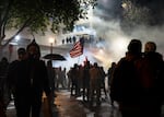 FILE - Hundreds of nonviolent protesters demonstrate as federal immigration officers deploy tear gas, flash-bangs and pepper balls outside the U.S. Immigrations and Customs building in Portland, Ore., Oct. 18, 2025. About 500 people gathered outside the facility to continue protesting following the “No Kings 2.0” rally.