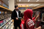 Darwaish Zakhil, co-founder of the Afghan Support Network and a former interpreter and cultural advisor with the U.S. Army, looks at books with two of his children at the Beaverton City Library in Beaverton, Ore., on Nov. 29, 2025. Zakhil and his wife, not pictured, immigrated to the U.S. in 2016 from Afghanistan.