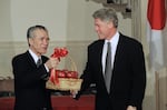 FILE - Japanese Prime Minister Tomiichi Murayama holds a basket of Washington state apples which President Bill Clinton gave him prior to the start of their joint news conference at the White House in Washington, Jan. 11, 1995.
