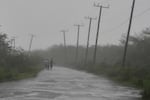 People walk along a road Tuesday during the passing of Hurricane Melissa in Rocky Point, Jamaica, Tuesday, Oct. 28, 2025. (AP Photo/Matias Delacroix)