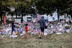 People walk in front of a memorial for slain conservative commentator Charlie Kirk, at Utah Valley University in Orem, Utah, on September 29, 2025.