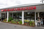 Fotos de Lisa Tran, sus padres, y otros miembros de la familia se encuentran en una repisa por encima de salsas Tân Tân a la venta en Tân Tân Café and Delicatessen, Beaverton, Ore., 13  de junio de 2025.